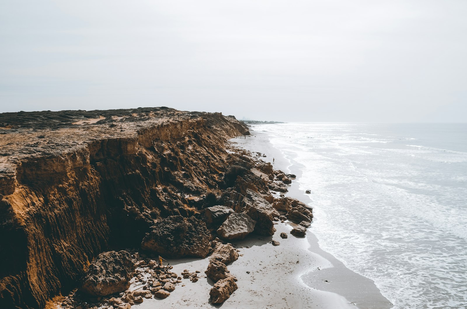 A dramatic coastal cliff meeting the open ocean under a wide sky