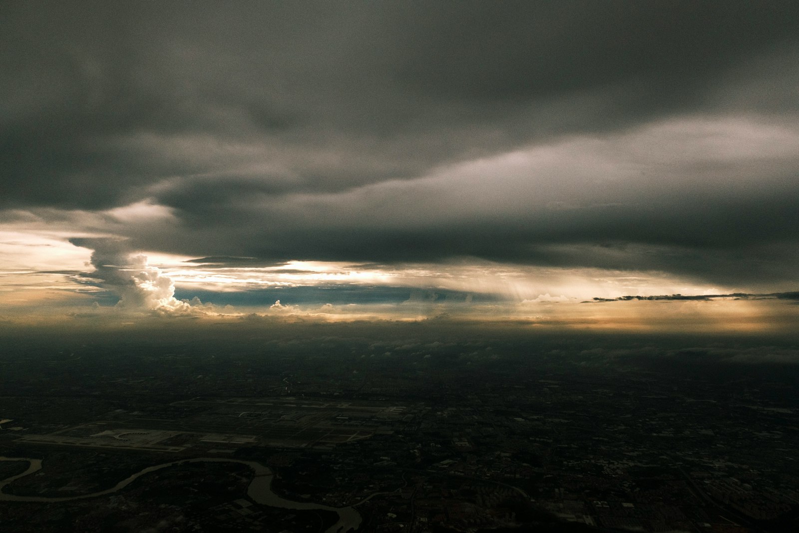 Dramatic storm clouds gathering over a dark, moody landscape