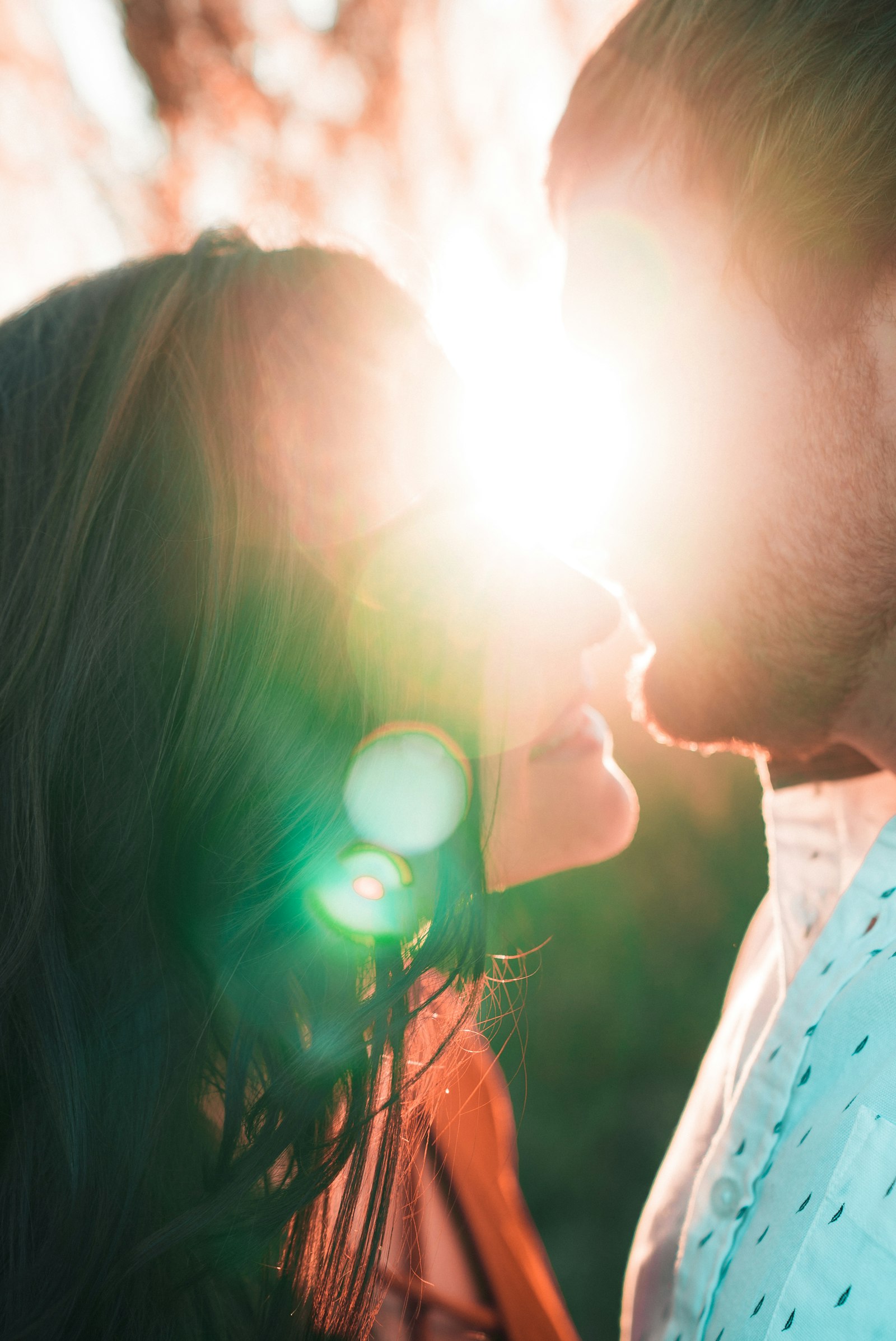 A couple kissing outdoors in high-contrast black and white