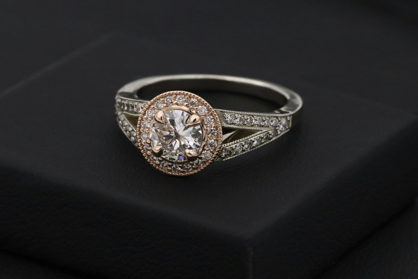 A single solitaire diamond ring presented on a black jewellery box under soft directional light.